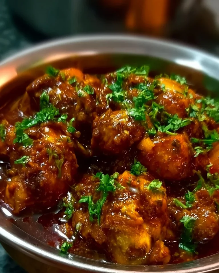 Plate of flavorful Chicken Masala garnished with fresh herbs