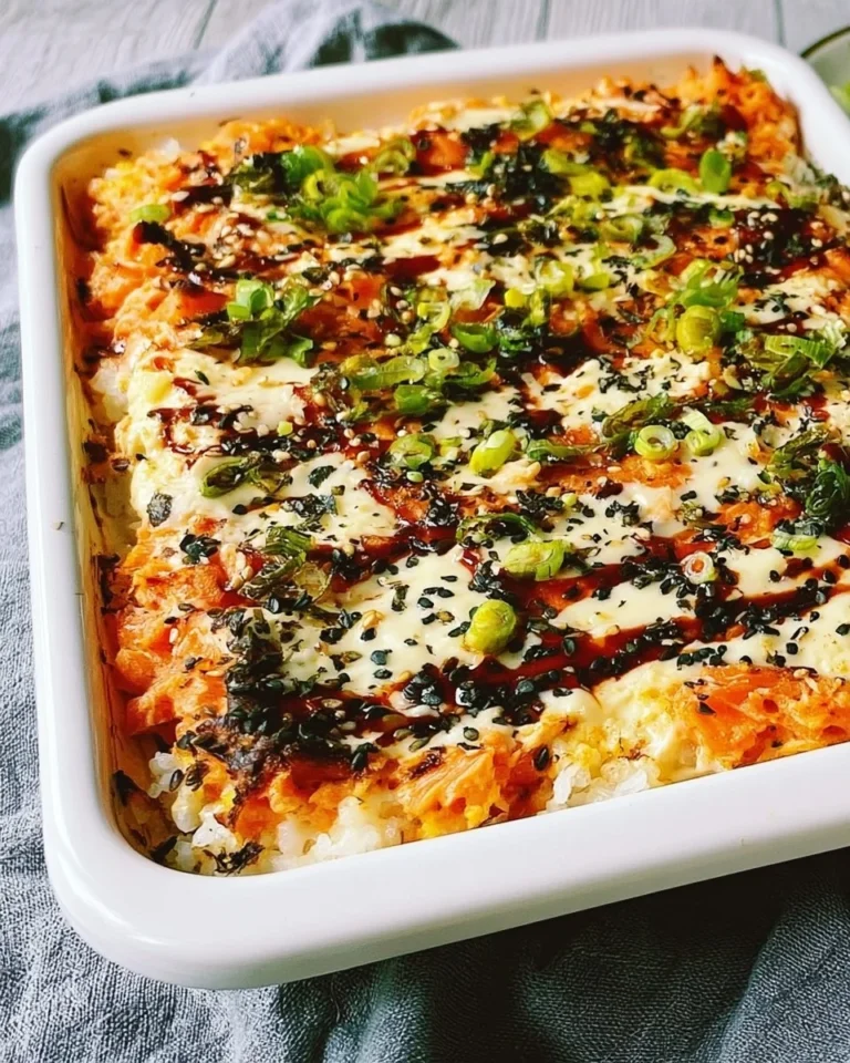Delicious salmon sushi bake with creamy topping and ingredients stacked in a baking dish